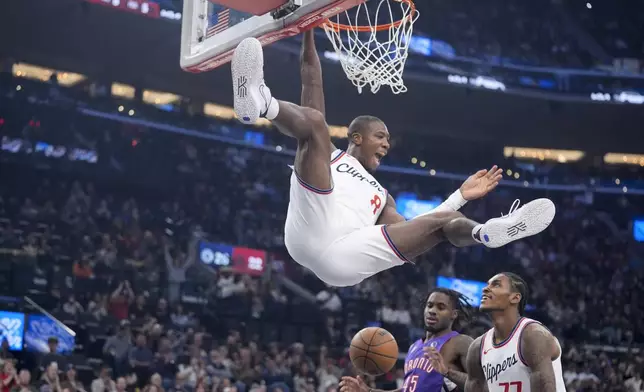 Los Angeles Clippers guard Kris Dunn (8) celebrates as he dunks during the first half of an NBA basketball game against the Toronto Raptors, Saturday, Nov. 9, 2024, in Inglewood, Calif. (AP Photo/Marcio Jose Sanchez)