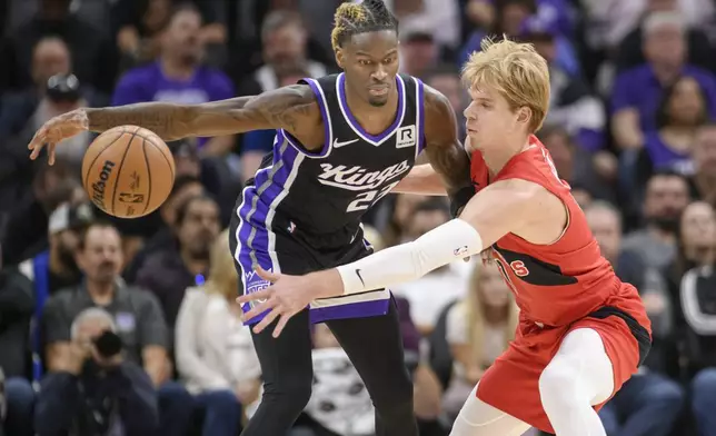 Sacramento Kings guard Keon Ellis, left, is guarded by Toronto Raptors guard Gradey Dick during the first half of an NBA basketball game in Sacramento, Calif., Wednesday, Nov. 6, 2024. (AP Photo/Randall Benton)