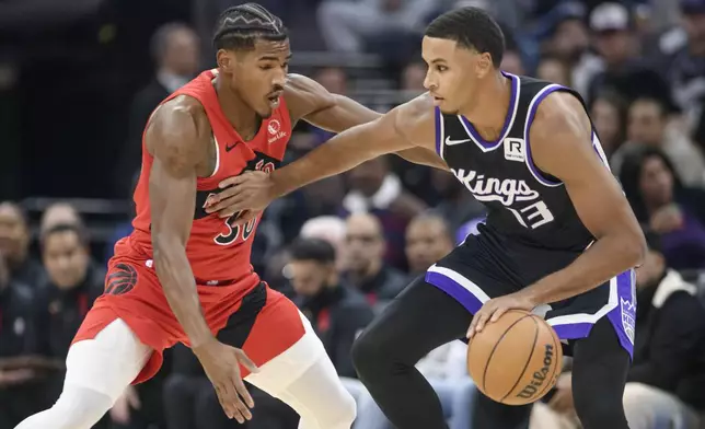 Toronto Raptors guard Ochai Agbaji, left, guards Sacramento Kings forward Keegan Murray during the first half of an NBA basketball game in Sacramento, Calif., Wednesday, Nov. 6, 2024. (AP Photo/Randall Benton)