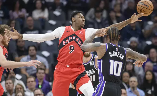 Toronto Raptors guard RJ Barrett (9) reaches for a rebound over Sacramento Kings forward DeMar DeRozan (10) during the first half of an NBA basketball game in Sacramento, Calif., Wednesday, Nov. 6, 2024. (AP Photo/Randall Benton)