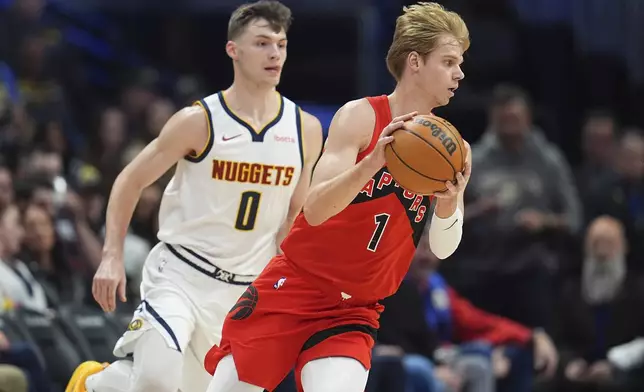 Toronto Raptors guard Gradey Dick, front, fields a pass as Denver Nuggets guard Christian Braun defends in the first half of an NBA basketball game Monday, Nov. 4, 2024, in Denver. (AP Photo/David Zalubowski)