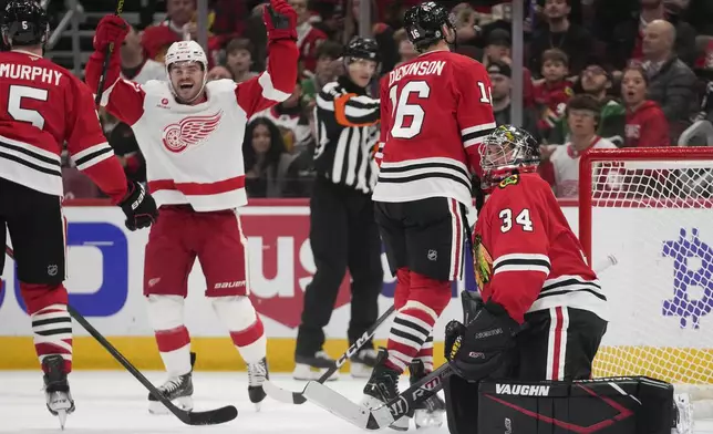 Detroit Red Wings right wing Alex DeBrincat, left, celebrates after scoring on Chicago Blackhawks goaltender Petr Mrazek during the first period of an NHL hockey game Wednesday, Nov. 6, 2024, in Chicago. (AP Photo/Erin Hooley)