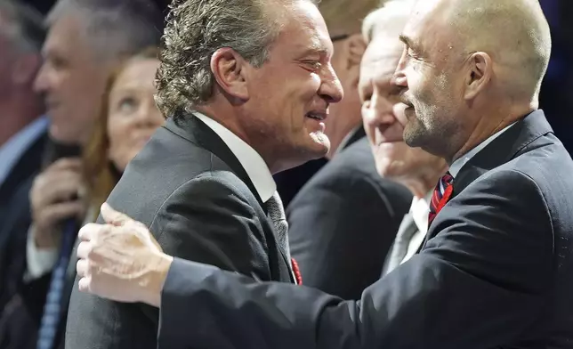 2024 Hockey Hall of Fame inductee Jeremy Roenick, left, is greeted by Ed Belfour, right, during a ceremony prior to NHL hockey game action between the Detroit Red Wings and the Toronto Maple Leafs in Toronto, Friday, Nov. 8, 2024. (Frank Gunn/The Canadian Press via AP)