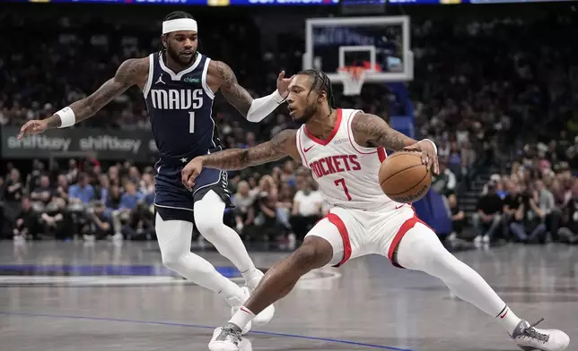 Houston Rockets forward Cam Whitmore (7) positions for a shot as Dallas Mavericks' Jaden Hardy (1) defends in the first half of an NBA basketball game in Dallas, Thursday, Oct. 31, 2024. (AP Photo/Tony Gutierrez)