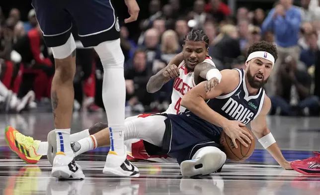 Dallas Mavericks guard Klay Thompson, front, grabs a loose ball in front of Houston Rockets guard Jalen Green (4) in the first half of an NBA basketball game in Dallas, Thursday, Oct. 31, 2024. (AP Photo/Tony Gutierrez)