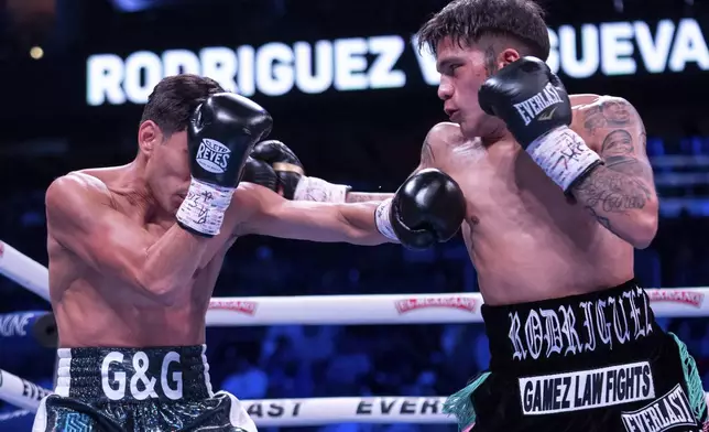 Jesse Rodriguez, right, throws a punch against Padro Guevara, left, during the first round of a WBC World and Ring Magazine Super-Flyweight titles bout Saturday, Nov. 9, 2024, in Philadelphia. Jesse Rodriguez retains his title with a third round TKO. (AP Photo/Chris Szagola)