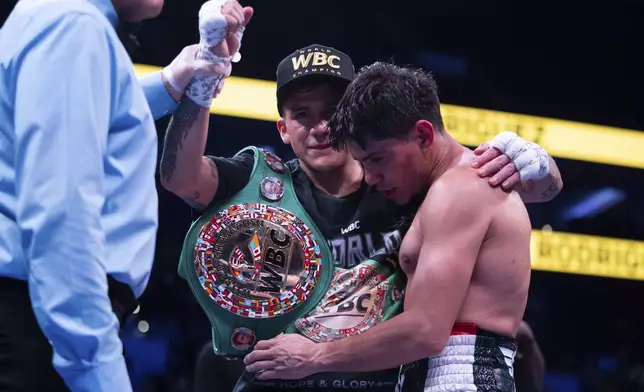 Jesse Rodriguez, center, celebrates his win as Padro Guevara, right, comes over to give him a hug following the WBC World and Ring Magazine Super-Flyweight titles bout Saturday, Nov. 9, 2024, in Philadelphia. Jesse "Bam" Rodriguez retains his title with a third round TKO. (AP Photo/Chris Szagola)