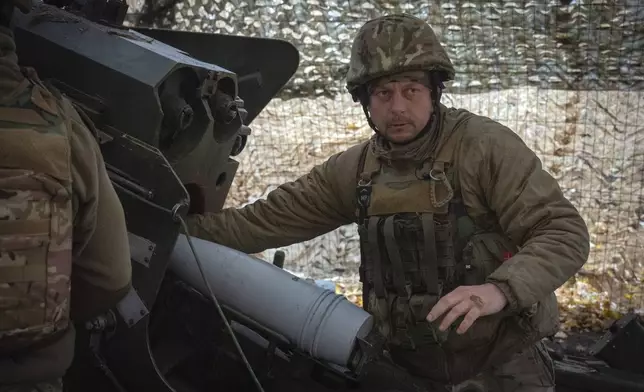 A serviceman of the 13th Brigade of the National Guard of Ukraine prepares to fire a Giatsint-B gun towards Russian positions near Kharkiv, Ukraine, Wednesday, Nov. 6, 2024. (AP Photo/Efrem Lukatsky)