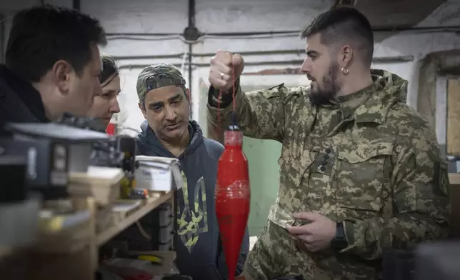 Amed Khan, a U.S. human rights advocate, political activist and philanthropist, center, listens to Yuri Fedorenko, commander of Ukraine's attack drones battalion "Achilles" in Kharkiv region, Ukraine, Sunday, Oct. 27, 2024. (AP Photo/Efrem Lukatsky)