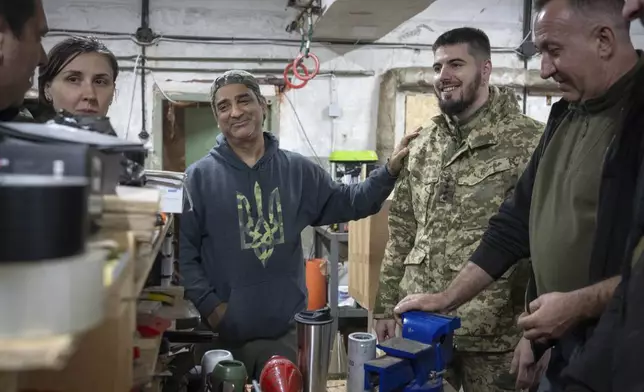 Amed Khan, a U.S. human rights advocate, political activist and philanthropist, center, listens to Yuri Fedorenko, commander of Ukraine's attack drones battalion "Achilles" in Kharkiv region, Ukraine, Sunday, Oct. 27, 2024. (AP Photo/Efrem Lukatsky)