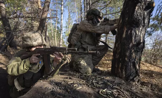 U.S. volunteers, 25-year-old fighter with callsign Dima from Texas, right, and Neko, who both serve with the 23rd separate rifle battalion of Ukraine's Armed Forces, hold position at the front line in the Kharkiv region, Ukraine, Saturday, Oct. 26, 2024. (AP Photo/Efrem Lukatsky)