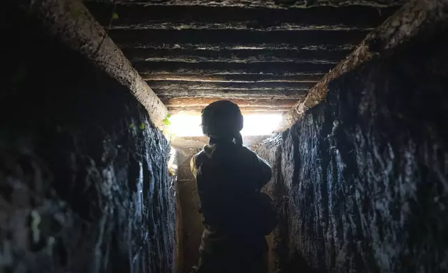 A U.S. volunteer Neko who serves with the 23rd separate rifle battalion of Ukraine's Armed Forces, fires at the front line in the Kharkiv region, Ukraine, Saturday, Oct. 26, 2024. (AP Photo/Efrem Lukatsky)