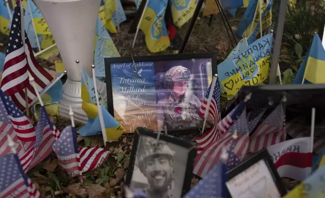 The memorial plate for Tatyana Millard, American volunteer, is seen among Ukrainian and American flags placed in honour of fallen servicemen in central Kyiv, Ukraine, Tuesday, Nov. 5, 2024. (AP Photo/Alex Babenko)