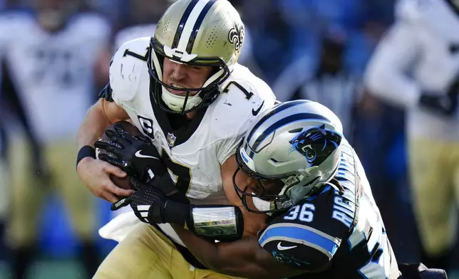 New Orleans Saints tight end Taysom Hill is tackled by Carolina Panthers safety Demani Richardson during the second half of an NFL football game Sunday, Nov. 3, 2024, in Charlotte, N.C. (AP Photo/Rusty Jones)