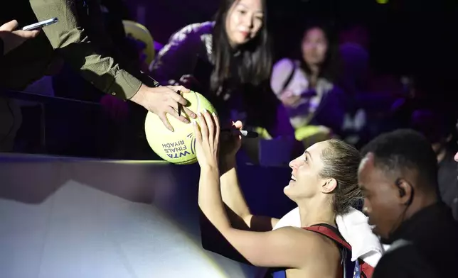 Canada's Gabriela Dabrowski, signs for fans during her women's doubles semi final match against Nicole Melichar-Martinez of the U.S. and Australia's Ellen Perez at King Saud University Indoor Arena, in Riyadh, Saudi Arabia, Friday, Nov. 8, 2024. (AP Photo)