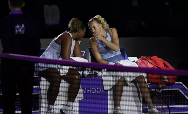 Taylor Townsend of the U.S., left, and Katerina Siniakova of the Czech Republic talk to each other during a changeover in their women's doubles match against New Zealand's Erin Routliffe and to Canada's Gabriela Dabrowski in the final of the WTA finals at King Saud University Indoor Arena, in Riyadh, Saudi Arabia, Saturday, Nov. 9, 2024. (AP Photo)