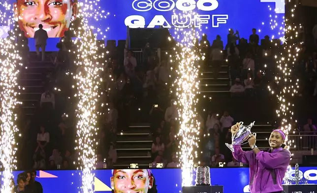 Coco Gauff of the U.S. holds her trophy after winning against China's Qinwen Zheng in their women's singles final match of the WTA finals at the King Saud University Indoor Arena, in Riyadh, Saudi Arabia, Saturday, Nov. 9, 2024. (AP Photo)