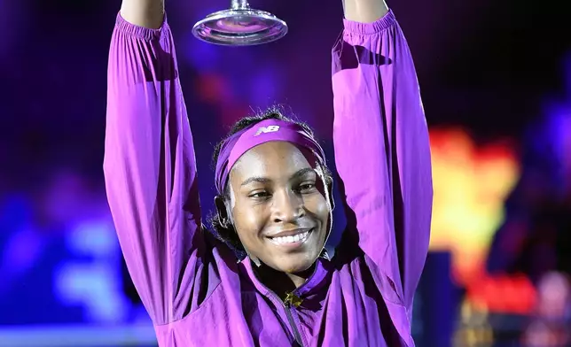 Coco Gauff of the U.S. holds her trophy after winning against China's Qinwen Zheng in their women's singles final match of the WTA finals at the King Saud University Indoor Arena, in Riyadh, Saudi Arabia, Saturday, Nov. 9, 2024. (AP Photo)