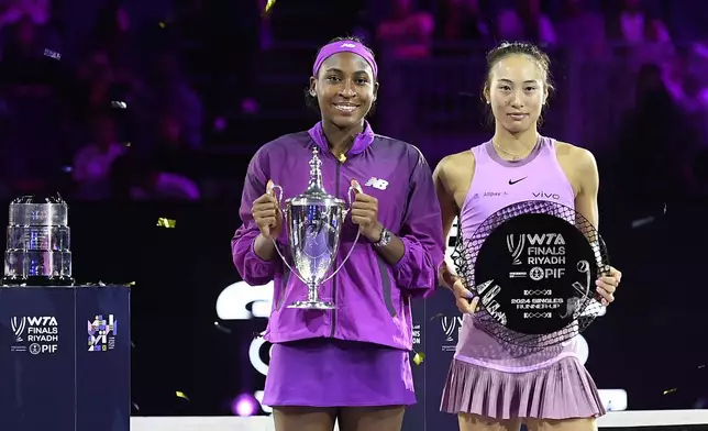 Winner Coco Gauff of the U.S., left, and runner-up China's Qinwen Zheng hold their trophies after their women's singles final match of the WTA finals at the King Saud University Indoor Arena, in Riyadh, Saudi Arabia, Saturday, Nov. 9, 2024. (AP Photo)