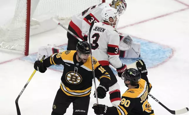 Boston Bruins' Pavel Zacha (18) celebrates his goal on Ottawa Senators' Linus Ullmark (35) with teammate Tyler Johnson (90) during the second period of an NHL hockey game, Saturday, Nov. 9, 2024, in Boston. (AP Photo/Michael Dwyer)