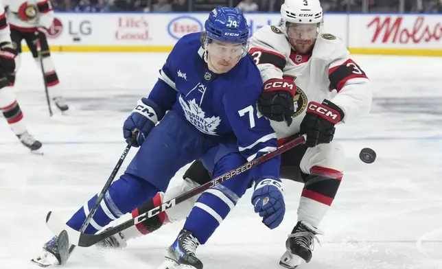 Toronto Maple Leafs' Bobby McMann, left, battles for the puck with Ottawa Senators' Nick Jensen during the second period of an NHL hockey game in Toronto, Tuesday, Nov. 12, 2024. (Chris Young/The Canadian Press via AP)