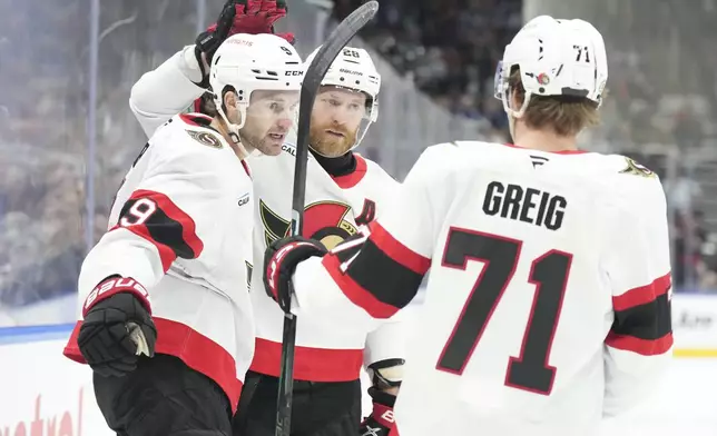 Ottawa Senators' Josh Norris (9) celebrates with Claude Giroux, center, and Ridly Greig (71) after scoring his team's opening goal against the Toronto Maple Leafs during the first period of an NHL hockey game in Toronto, Tuesday, Nov. 12, 2024. (Chris Young/The Canadian Press via AP)