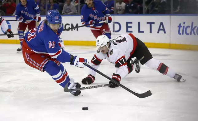 New York Rangers forward Artemi Panarin, left, and Ottawa Senators forward Zack MacEwen battle for the puck during the second period of an NHL hockey game, Friday, Nov. 1, 2024, in New York. (AP Photo/John Munson)