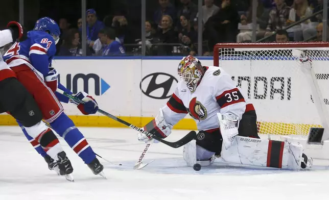 Ottawa Senators goalie Linus Ullmark, right, makes a save on New York Rangers center Adam Edstrom, left, during the first period of an NHL hockey game, Friday, Nov. 1, 2024, in New York. (AP Photo/John Munson)