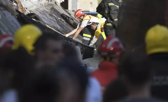 Rescue workers search for victims in the aftermath of an outdoor roof collapsed at a train station in Novi Sad, Serbia, Friday, Nov. 1, 2024. (AP Photo)
