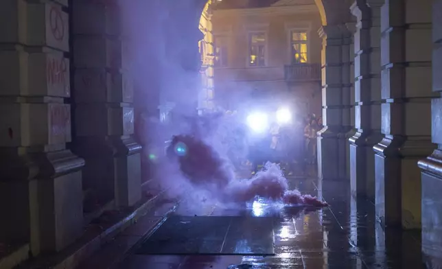 A flare burns in front of the City Hall building during a protest in rage over last week's collapse of a concrete canopy at the railway station that killed 14 people, in Novi Sad, Serbia, Tuesday, Nov. 5, 2024. (AP Photo/Marko Drobnjakovic)