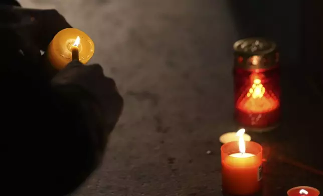 People light candles for the victims after an outdoor roof collapsed at a train station in Novi Sad, Serbia, Friday, Nov. 1, 2024. (AP Photo/Darko Vojinovic)