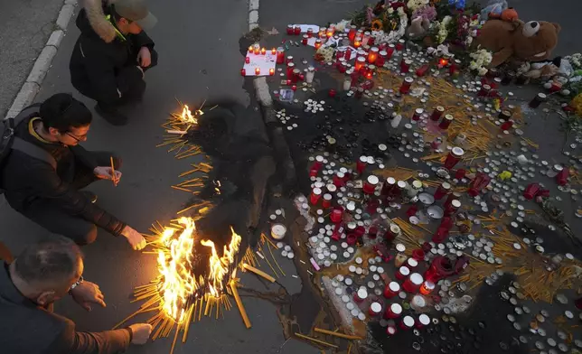 People light candles for the victims of an outdoor roof collapse at a train station in Novi Sad, Serbia, Saturday, Nov. 2, 2024. (AP Photo/Darko Vojinovic)