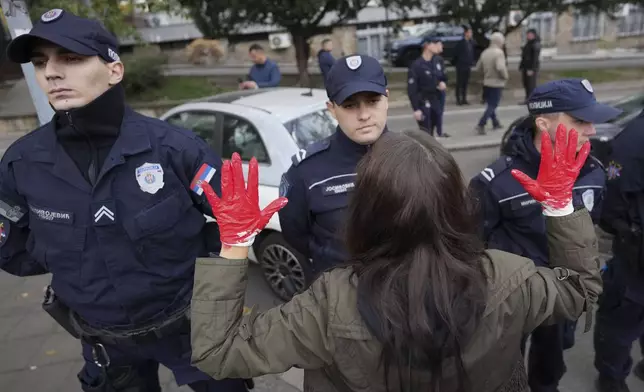 Protesters shout slogans with red paint on the hands symbolizing blood, demanding arrests, two days after a concrete canopy collapsed at a railway station in Novi Sad, killing 14 people and injuring three, during protest in Belgrade, Serbia, Sunday, Nov. 3, 2024. (AP Photo/Darko Vojinovic)