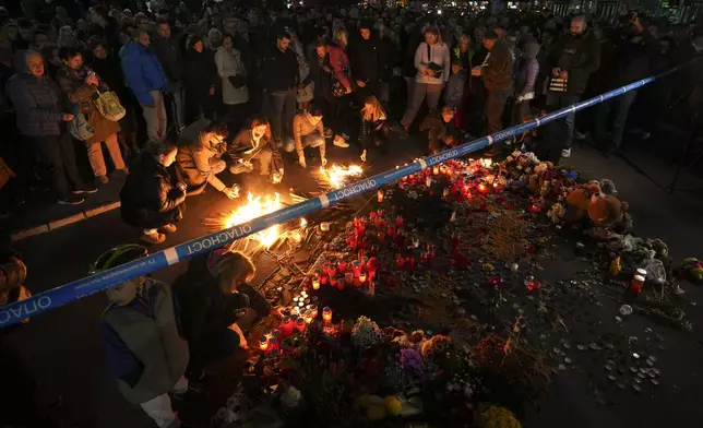 People light candles for the victims of an outdoor roof collapse at a train station in Novi Sad, Serbia, Saturday, Nov. 2, 2024. (AP Photo/Darko Vojinovic)