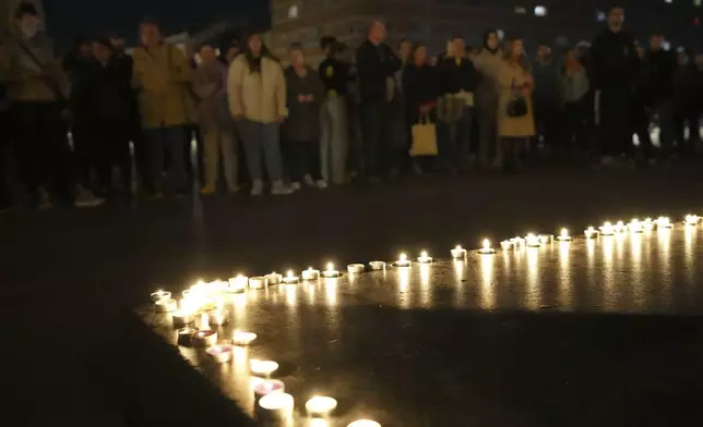 People light candles for the victims after an outdoor roof collapsed at a train station in Novi Sad, Serbia, Friday, Nov. 1, 2024. (AP Photo/Darko Vojinovic)