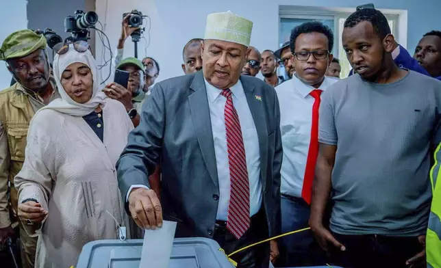 Presidential candidate Abdirahman Mohamed Abdullahi, center, casts his vote inside a polling station during the presidential election in Hargeisa, Somaliland, Wednesday, Nov. 13,2024. (AP Photo/Abdirahman Aleeli)