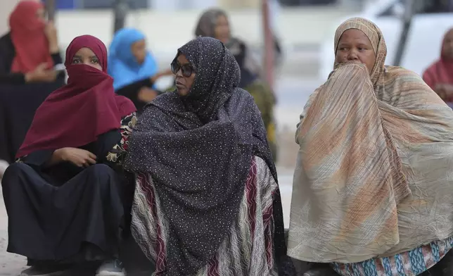 Women sit down on the floor as they wait to cast their vote during the 2024 Somaliland presidential election, at a polling station in Hargeisa, Somaliland, Wednesday, Nov. 13,2024. (AP Photo/Abdirahman Aleeli)