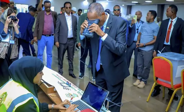 Somaliland President Muse Bihi Abdi, center, gets his biometrics registered before casting his vote inside a polling station during the presidential election in Hargeisa, Somaliland, Wednesday, Nov. 13,2024. (AP Photo/Abdirahman Aleeli)