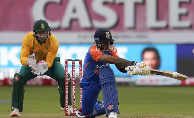 India's captain Suryakumar Yadav, right, plays a side shot as South Africa's wicketkeeper Heinrich Klaasen looks on during the T20 International cricket match between South Africa and India, at Kingsmead stadium in Durban, South Africa, Friday, Nov. 8, 2024. (AP Photo/Themba Hadebe)