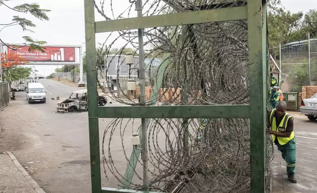 A worker closes the border crossing to Mozambique, in Lebombo, South Africa, Thursday, Nov. 7, 2024. South Africa closed its border with Mozambique shortly after opening it on Thursday as post-election violence in the neighboring country escalated. (AP Photo)