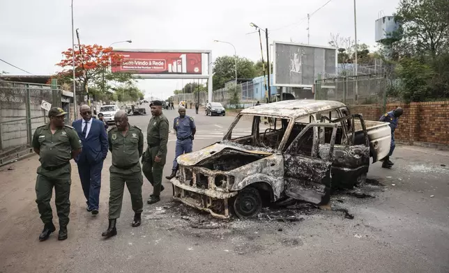 Border officials inspect a burnt-out Mozambican border patrol vehicle at the border crossing in Lebombo, South Africa, Thursday, Nov. 7, 2024. South Africa closed its border with Mozambique shortly after opening it on Thursday as post-election violence in the neighboring country escalated. (AP Photo)