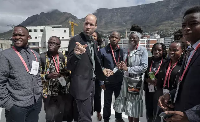 Britain's Prince William, speaks to a group of young people, with Table Mountain in the background at the Earthshot Prize Climate Leaders Youth Programme at Rooftop on Bree in Cape Town, South Africa, Monday Nov. 4, 2024. (Gianluigi Guercia/Pool Photo via AP)