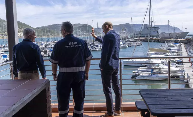 Britain's Prince William waves to well-wishers during his visit with volunteers of the National Sea Rescue Initiative, at Simon's Town harbour near Cape Town, South Africa, Thursday, Nov. 7, 2024. (AP Photo/Jerome Delay, Pool)