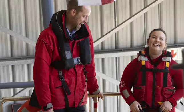 Britain's Prince William shares a laugh with one of the volunteers of the National Sea Rescue Initiative near Simon's Town harbour, in Cape Town, South Africa, Thursday, Nov. 7, 2024. (AP Photo/Jerome Delay, Pool)