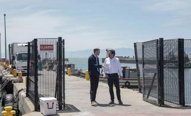 Britain's Prince William, the Prince of Wales, speaks to Co-owner of ABALOBI Serge Raemaeker, who were 2023 Earthshot finalists, at Kalk Bay Harbour, near Cape Town, Thursday, Nov. 7, 2024. (Gianluigi Guercia/Pool Photo via AP)