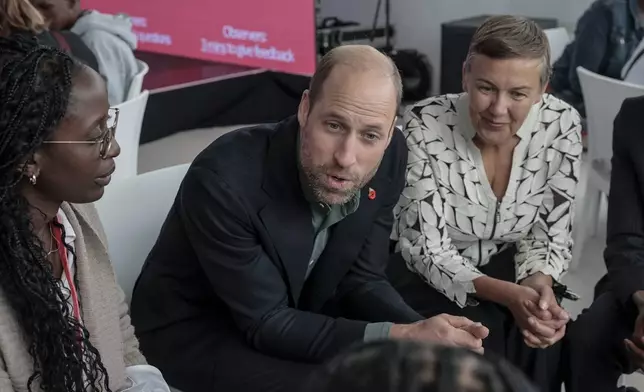 Britain's Prince William, center, and Hannah Jones, right, CEO of The Earthshot Prize, speak to a group of young people at the Earthshot Prize Climate Leaders Youth Programme at Rooftop on Bree in Cape Town, South Africa, Monday Nov. 4, 2024. (Gianluigi Guercia/Pool Photo via AP)