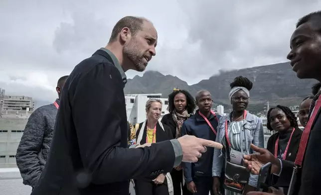 Britain's Prince William, speaks to a group of young people, with Table Mountain in the background at the Earthshot Prize Climate Leaders Youth Programme at Rooftop on Bree in Cape Town, South Africa, Monday Nov. 4, 2024. (Gianluigi Guercia/Pool Photo via AP)