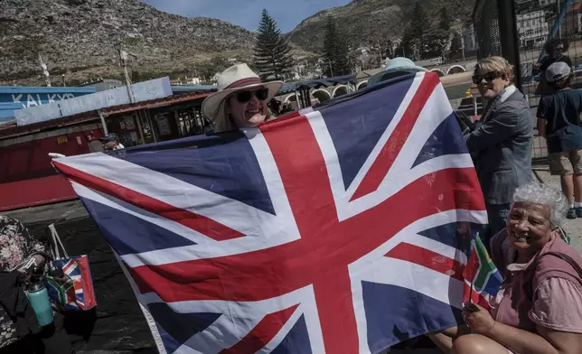 Well-wishers hold British and South African flags as they wait for Britain's Prince William, at Kalk Bay Harbour, near Cape Town, Thursday, Nov. 7, 2024. (Gianluigi Guercia/Pool Photo via AP)