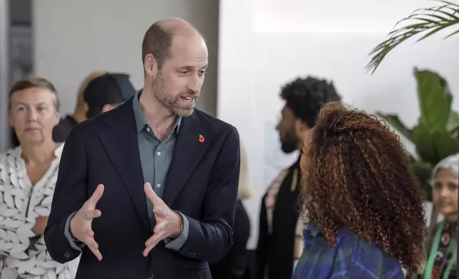 Britain's Prince William, left, speaks to an attendee at the Earthshot Prize Climate Leaders Youth Programme at Rooftop on Bree in Cape Town, South Africa, Monday Nov. 4, 2024. (Gianluigi Guercia/Pool Photo via AP)