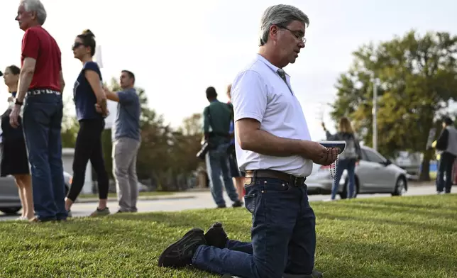 A protestor kneels to pray prior to the scheduled execution of Richard Moore, Friday, Nov. 1, 2024, outside of Broad River Correctional Institution in Columbia , S.C. (AP Photo/Matt Kelley)